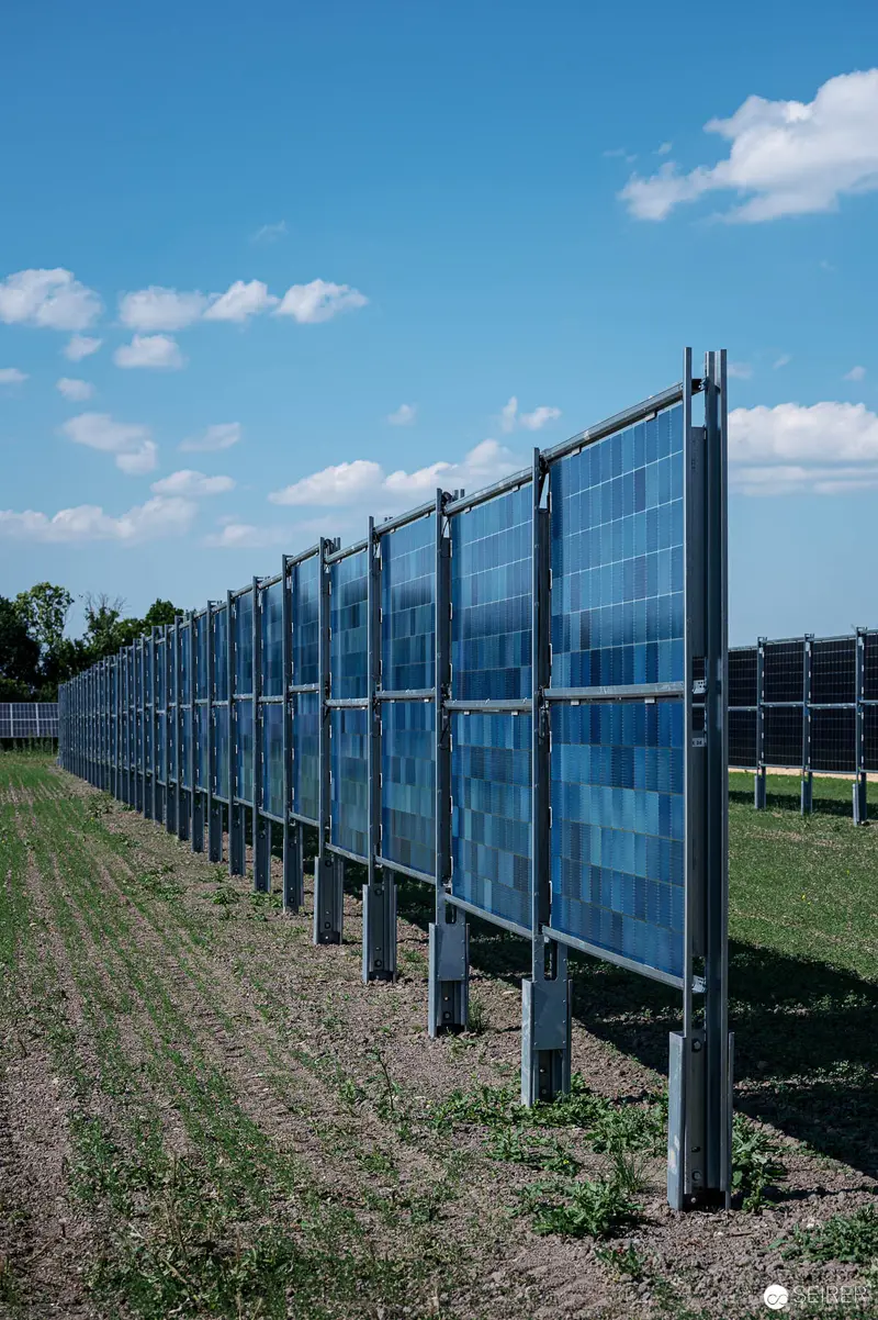 Solar Panel Array on Metal Framework Against Agricultural Landscape