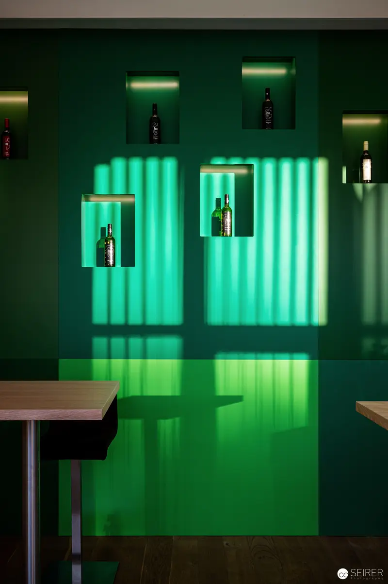 Emerald Bar Interior with Illuminated Bottle Displays and Minimalist Furniture