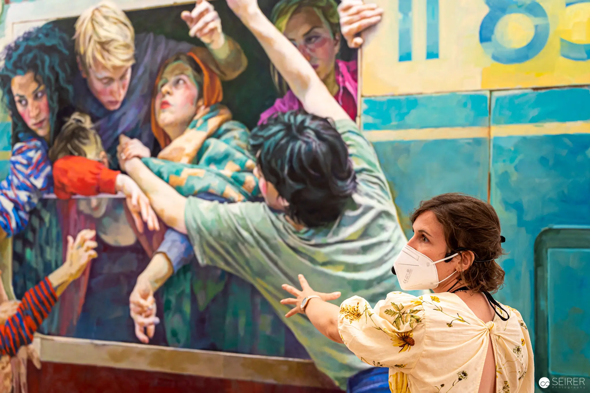 Xenia Hausner's "True Lies" Exhibition: Viewer Engaging with Painted Crowd at Albertina
