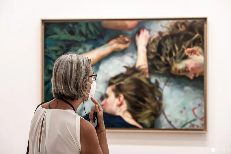 Viewer Contemplating Figurative Painting at Xenia Hausner's "True Lies" Exhibition