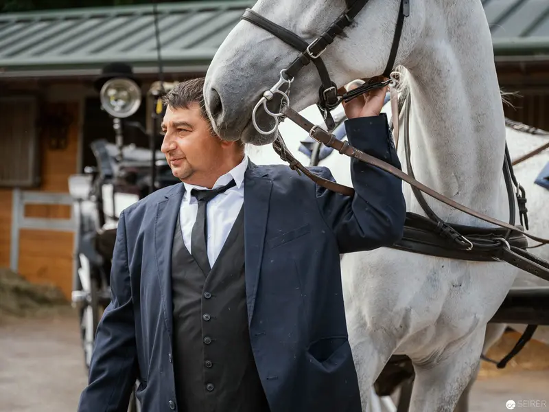 Elegantly Dressed Performer Posing with White Horse at Riding Dinner Event