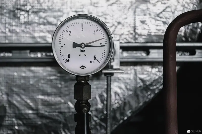 Industrial Pressure Gauge Against Metallic Reflective Background