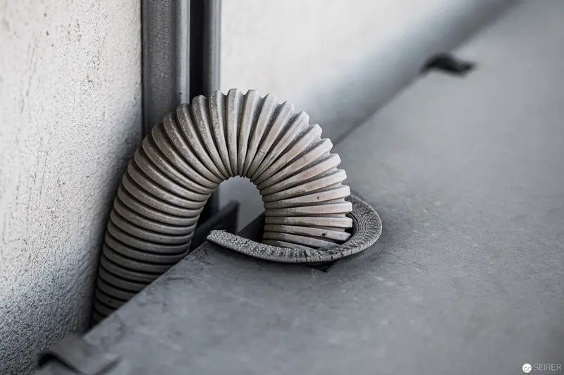 Corrugated Ventilation Tube Curving Elegantly Against Minimalist Industrial Surface