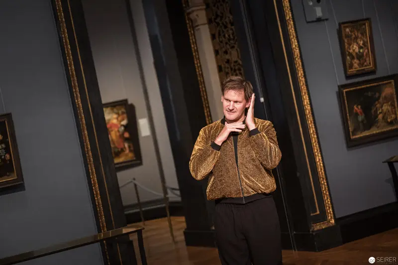 Performance Ganymed: Gold-Clad Performer Gesturing in Museum Gallery