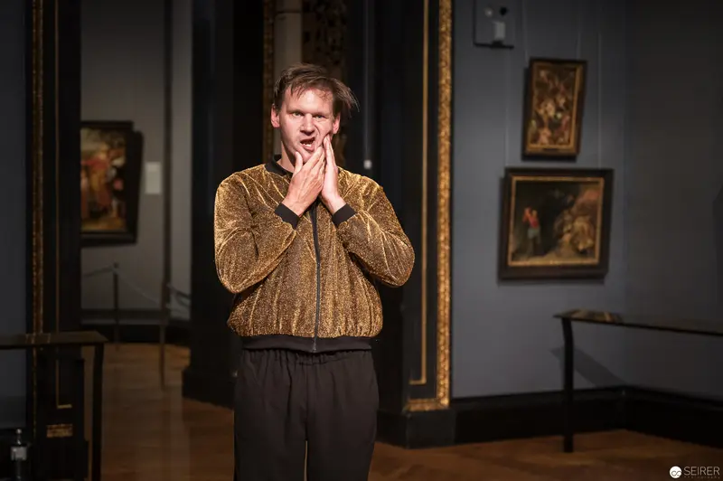 Performer in Golden Jacket Gesturing Dramatically at Kunsthistorisches Museum Wien
