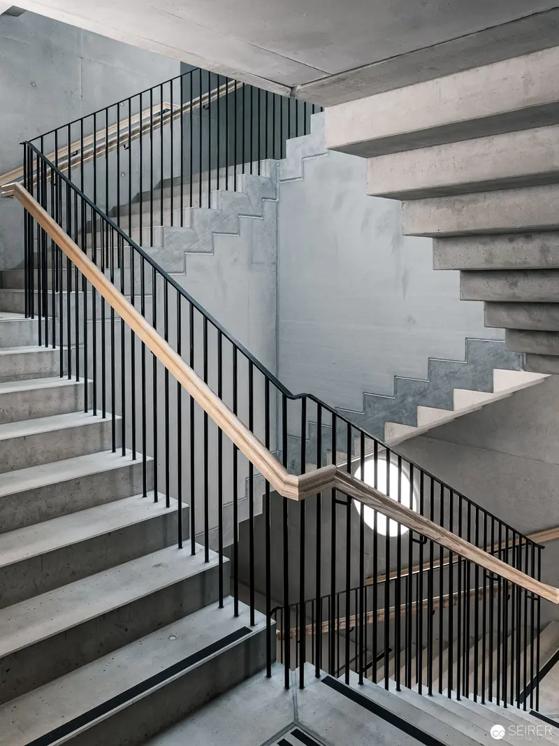 Monochromatic Architectural Staircase with Geometric Metalwork and Concrete Composition