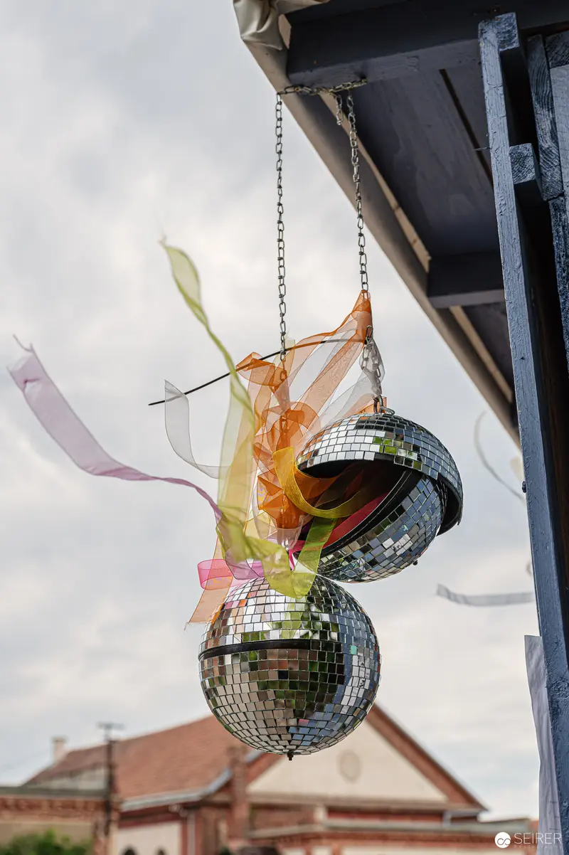 Disco Balls and Delicate Ribbons Suspended from Architectural Overhang