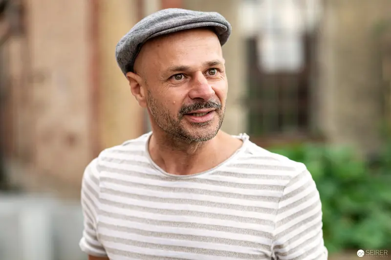 Mature Man in Striped Shirt and Flat Cap Outdoors