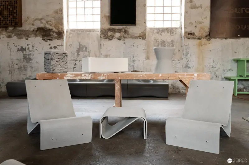 Minimalist Seating in Industrial Space: Concrete Chairs and Wooden Table