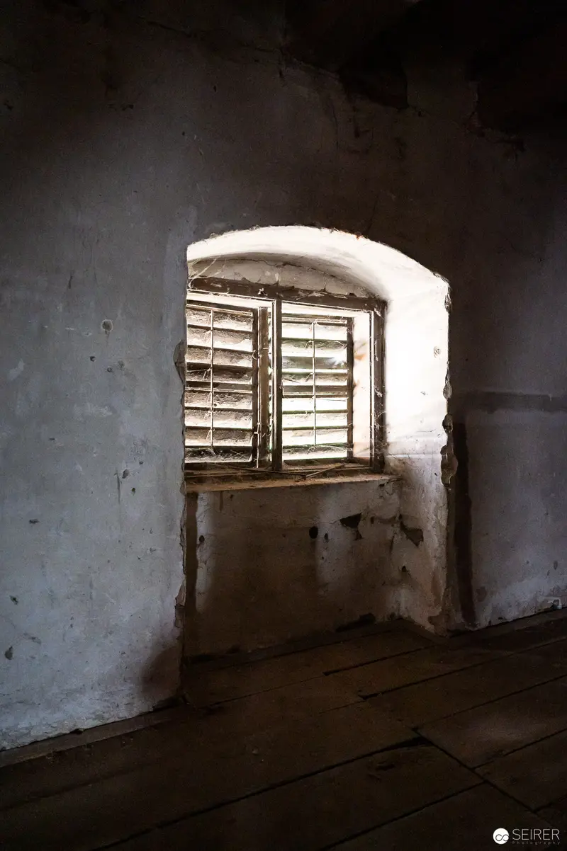Weathered Window in Abandoned Interior, Soft Light Breaking Through Shutters