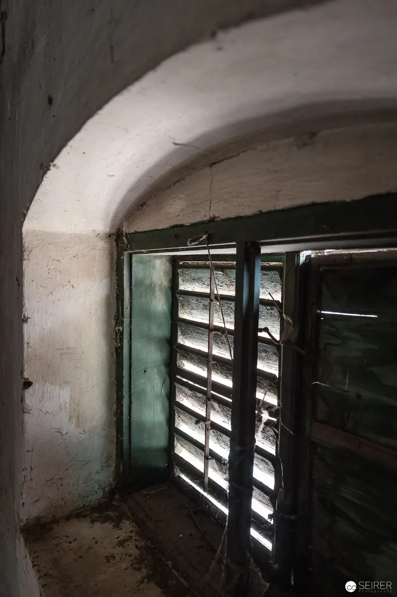 Weathered Window with Louvered Shutters in Decaying Interior Space