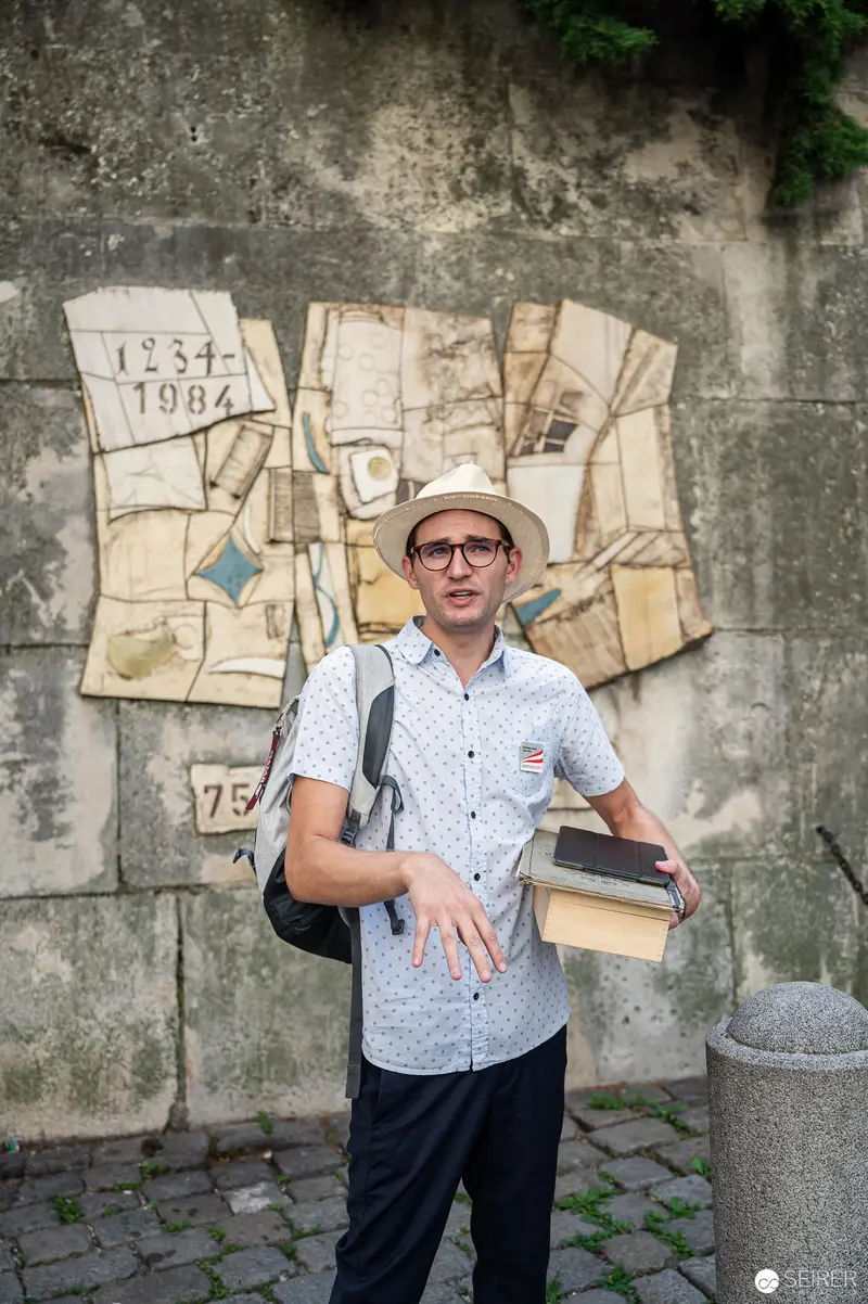 Scholar with Historical Documents Amid Urban Architectural Backdrop