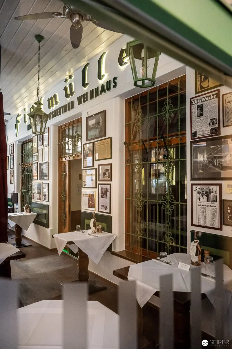Dimly Lit Viennese Café Interior with Historical Photographic Displays