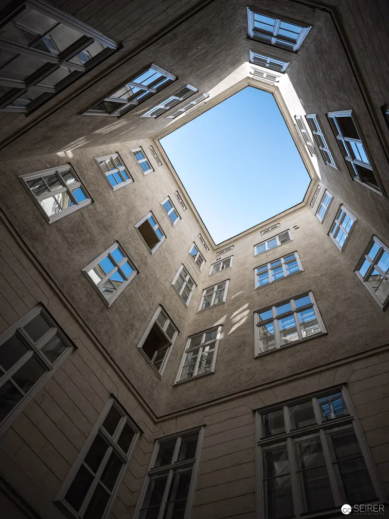 Geometric Architectural Perspective: Courtyard Viewed from Below Through Symmetrical Windows
