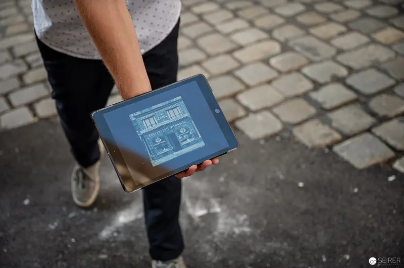 Blue-Screened Tablet Held Against Cobblestone Backdrop During Vienna Urban Tour