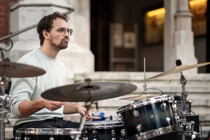 Drummer in Contemplative Pose During Outdoor Performance at Musik Befreit Concert