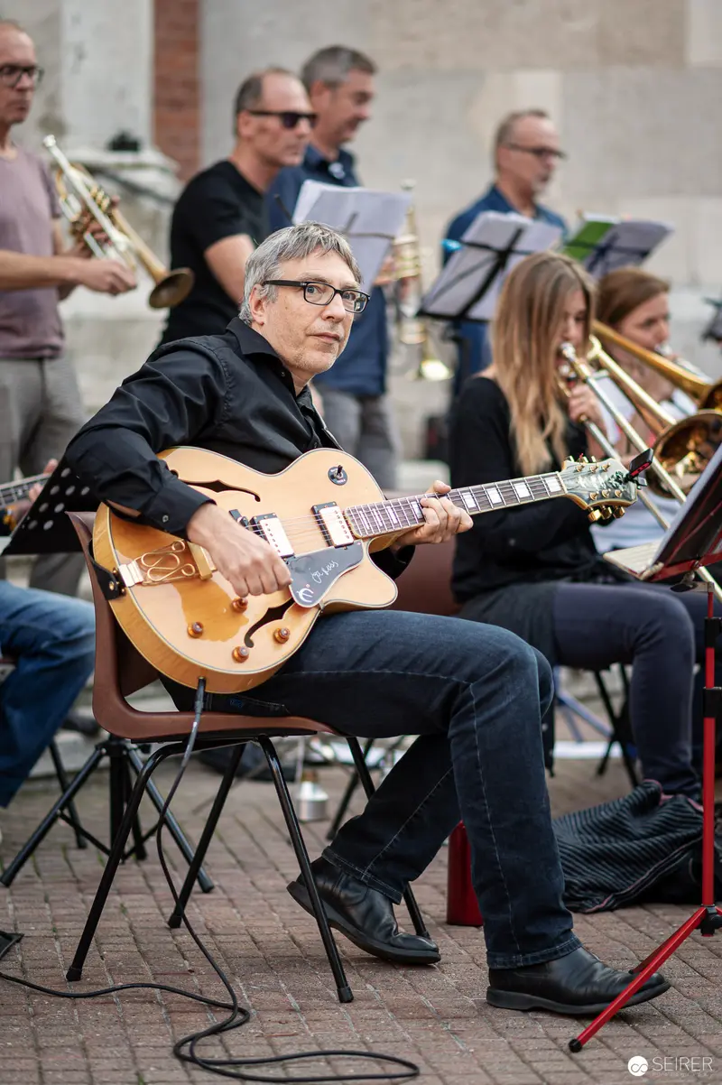 Guitarist Performing with Brass Ensemble at Musik Befreit Abschlusskonzert