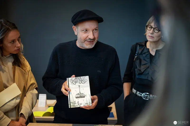 Vienna Design Week IgersWalk: Designer Presenting Illustrated Book in Gallery Setting