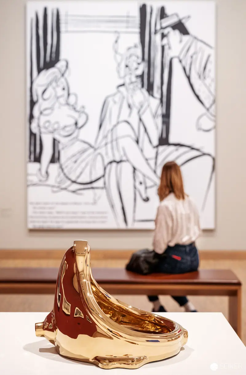Golden Banana Sculpture with Gallery Visitor at Albertina Modern's 80s Art Exhibition