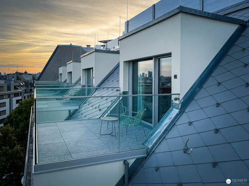 Modern Rooftop Terrace with Glass Balustrade at Sunset in Urban Setting