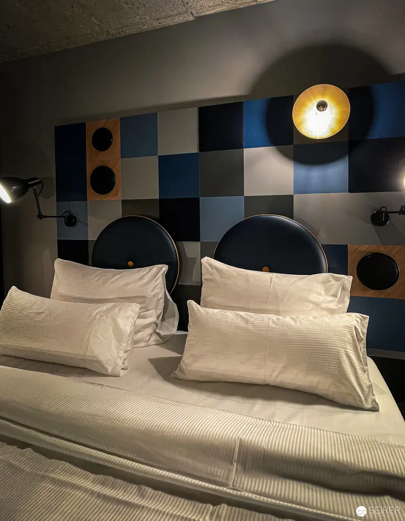Contemporary Hotel Room Interior with Geometric Blue and Beige Tiled Headboard