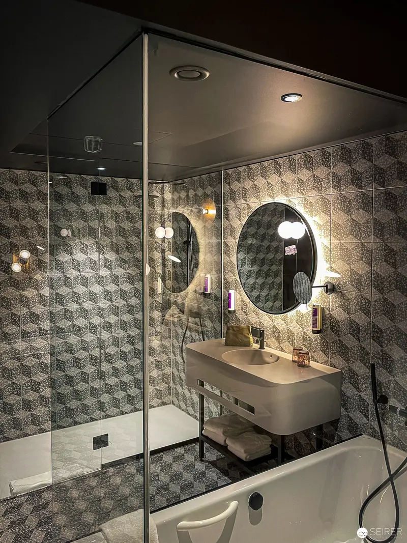 Contemporary Bathroom Interior with Geometric Tile and Illuminated Mirror Design