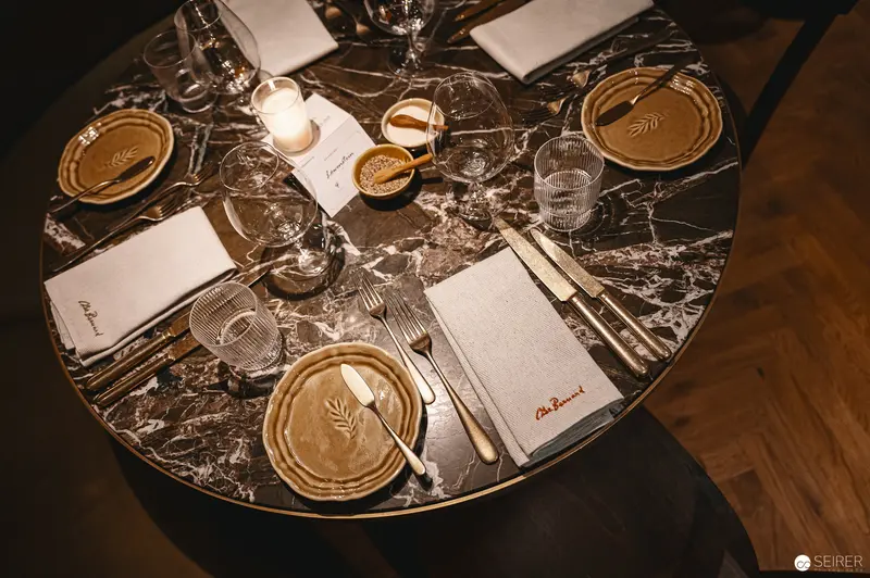 Intimate Table Setting with Golden Plates on Marble Surface at Hotel Motto, Vienna