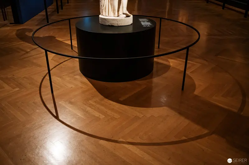 Sculptural Display of Marble Statue on Black Pedestal in Museum Gallery