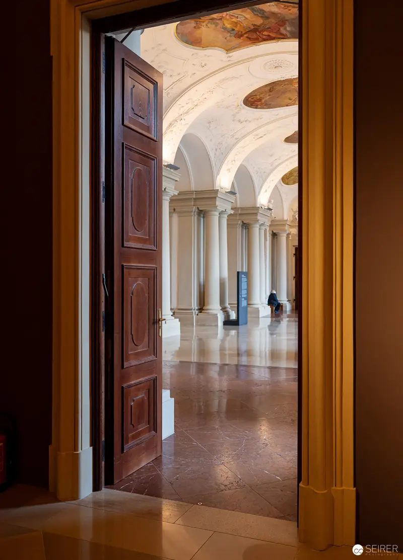 Ornate Architectural Interior Revealed through Partially Open Wooden Door