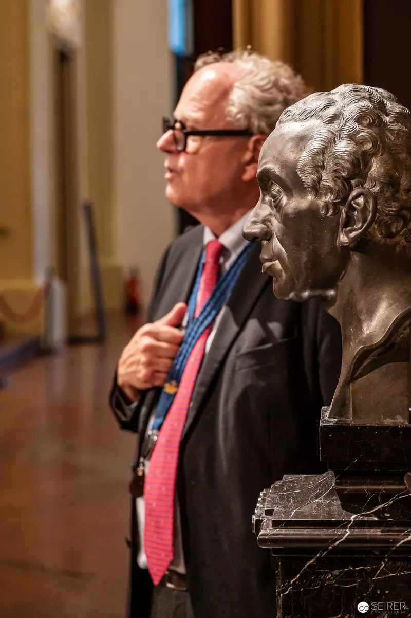 Bronze Bust and Suited Scholar in Contemplative Museum Space