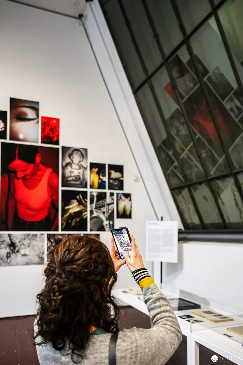 Visitor Documenting Art Exhibition at FOTO WIEN 2022 Gallery Space