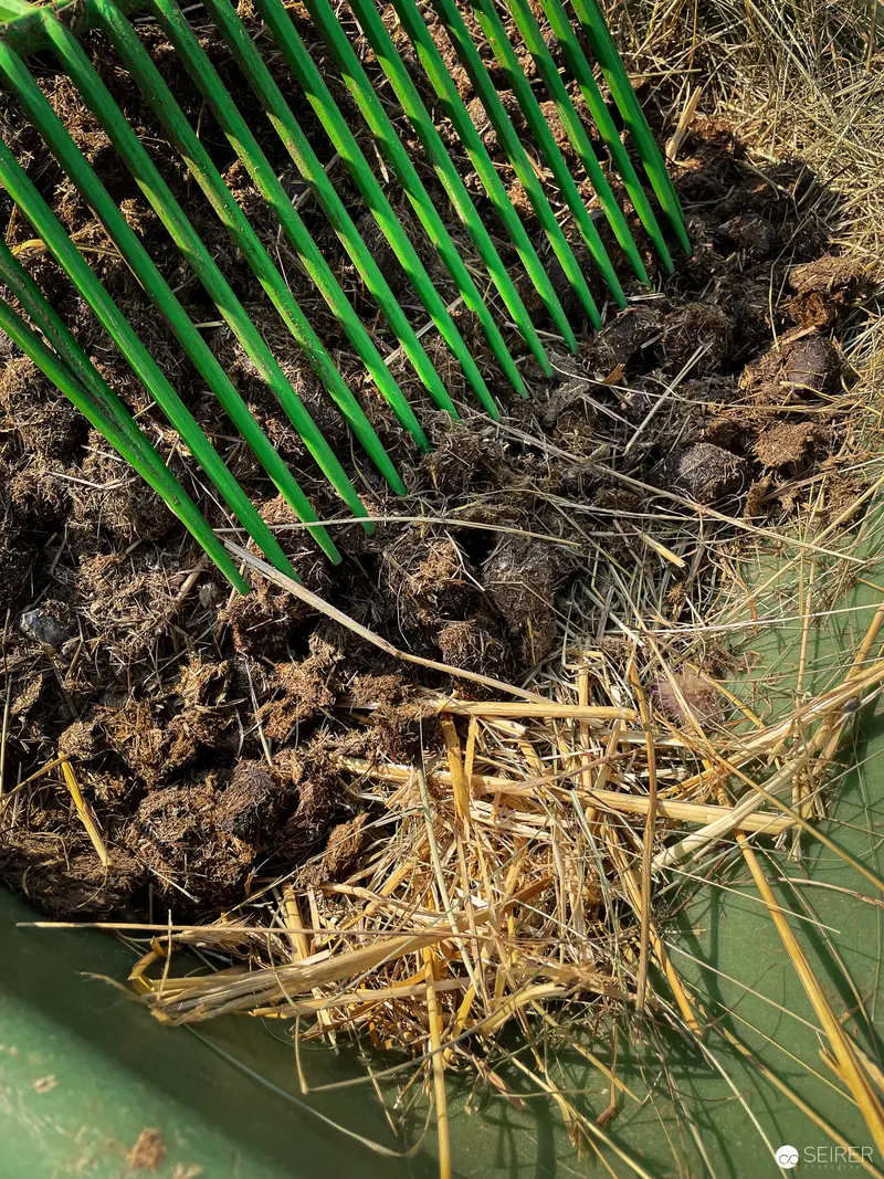 Green Pitchfork Amidst Agricultural Detritus and Straw