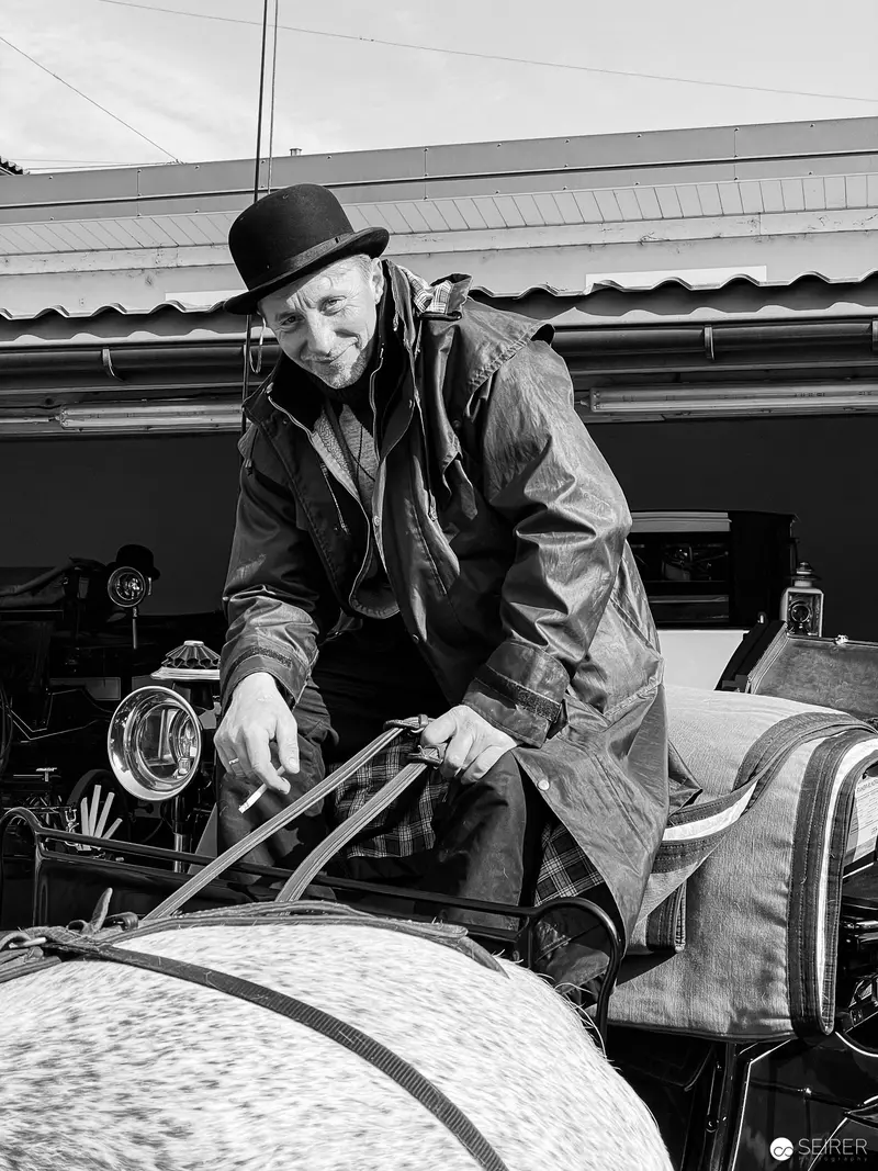 Vienna Fiaker Maintenance: Skilled Coachman Adjusting Vintage Horse-Drawn Carriage