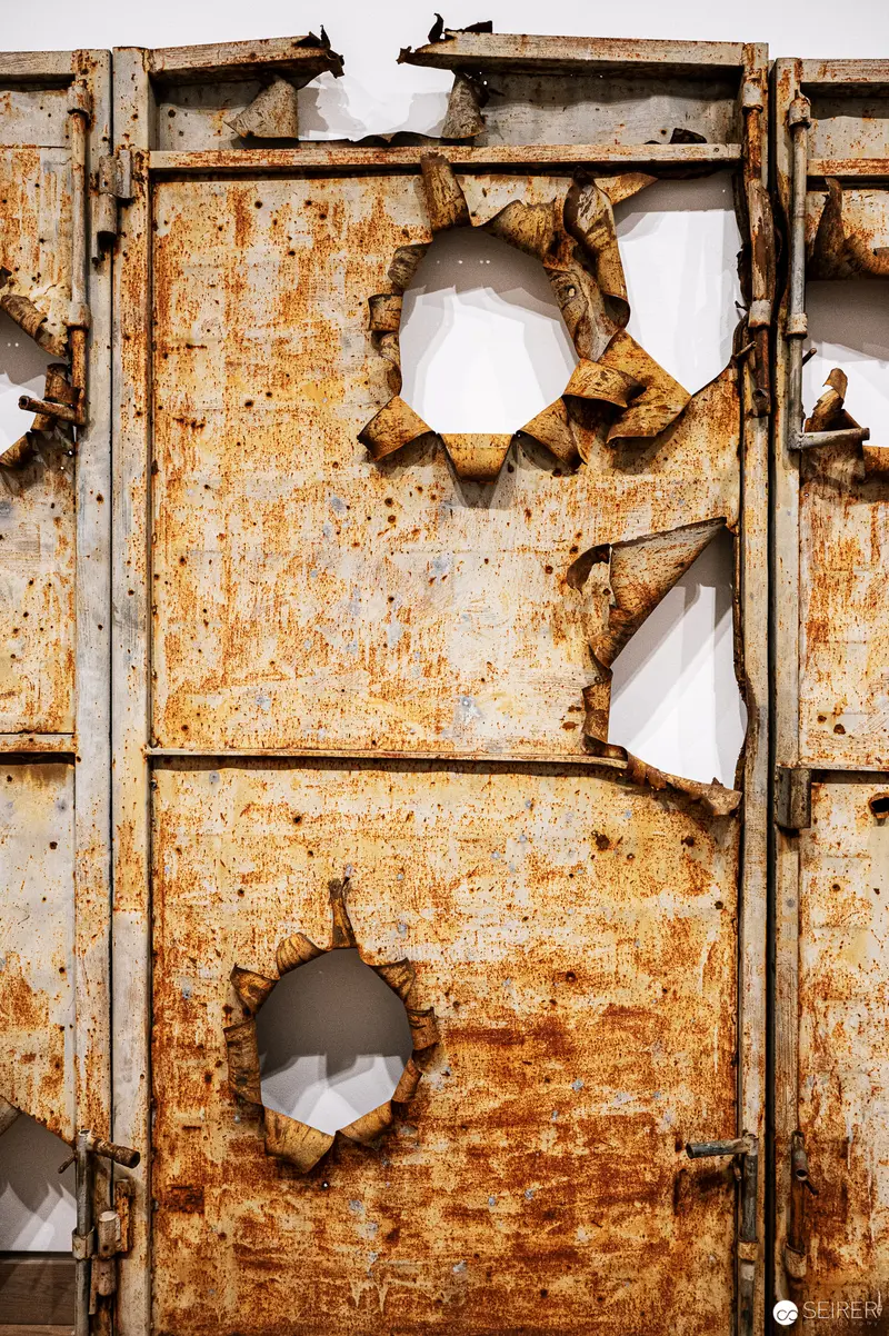 Rusted Metal Panel with Irregular Punctures Revealing Interior Void