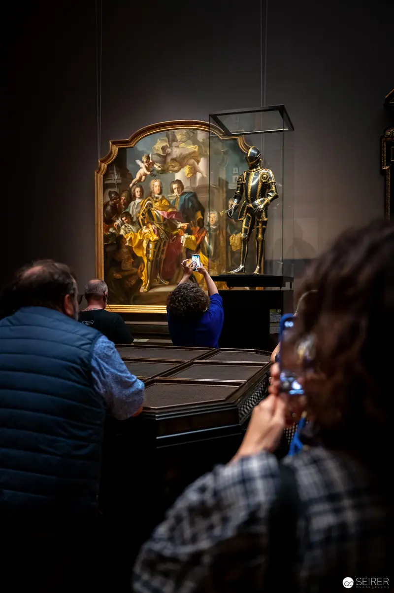 Museum Visitors Contemplating Baroque Religious Artwork at "Iron Men" Exhibition