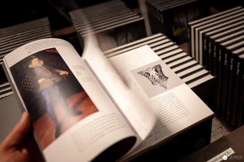 Art Book Open to Pages Revealing Historical Artwork in Museum Setting