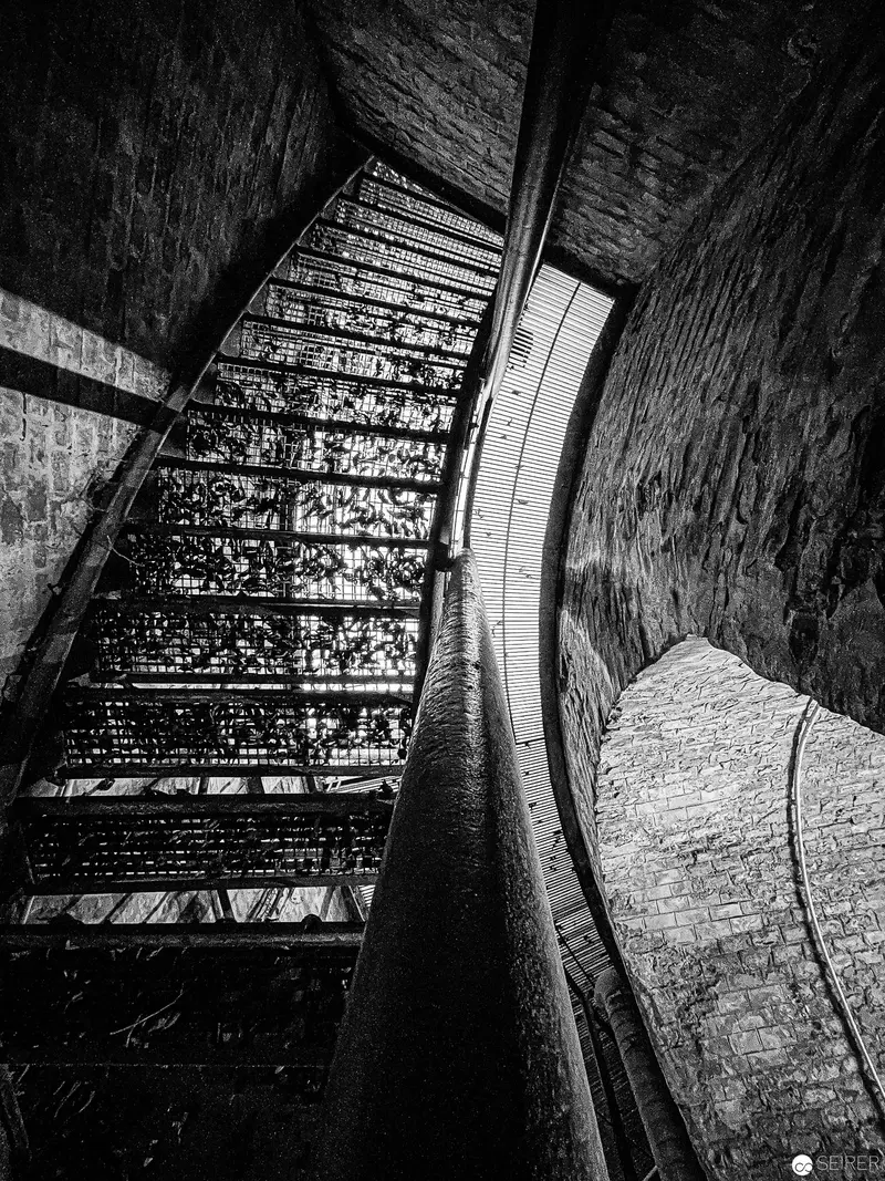 Architectural Black and White: Curved Brick Tunnel with Metal Staircase