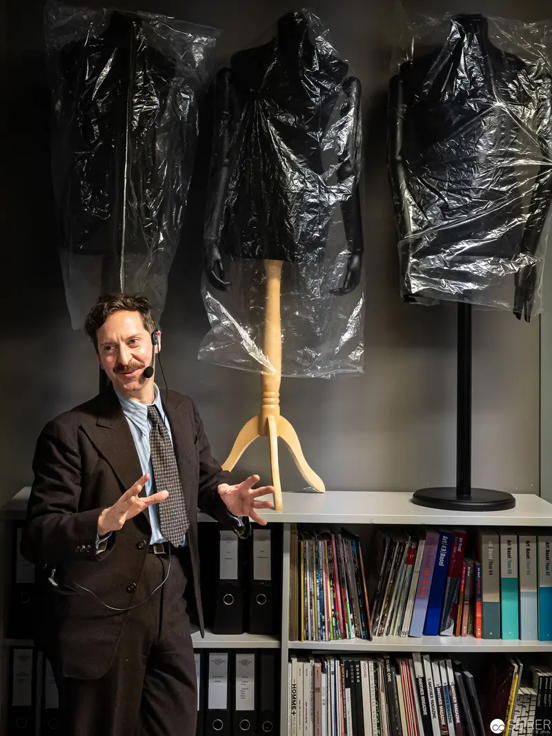 Curator with Hanging Objects in Black Plastic at Museum Exhibition