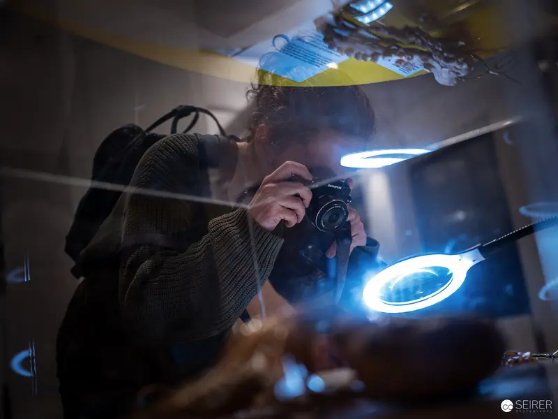 Photographer at Work Under Luminescent Magnifying Lamp