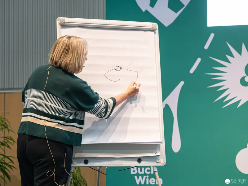 Buch Wien 2022: Woman Drawing Sketch on Whiteboard During Presentation