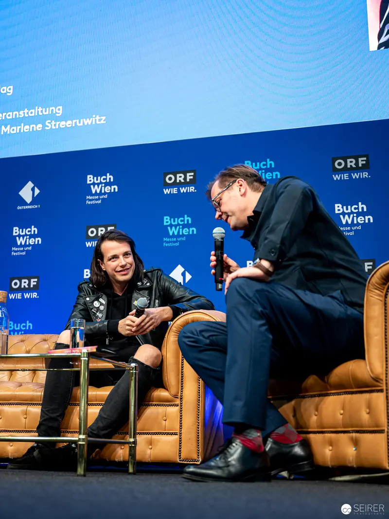 Two Speakers Engaged in Discussion at Buch Wien 2022 Literary Event