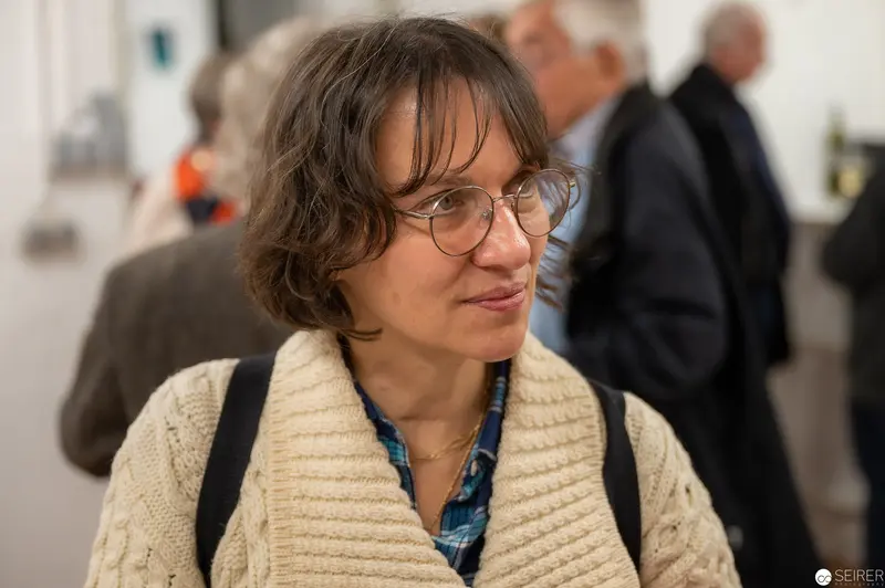 Scholarly Figure in Knit Cardigan at Academic Symposium or Conference