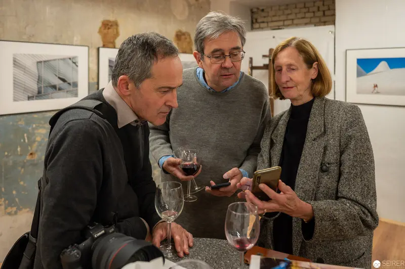 Art Gallery Gathering: Colleagues Discussing Photographs with Wine Glasses
