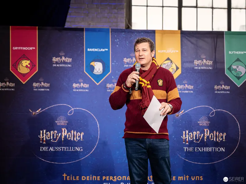 Harry Potter Exhibition Speaker in Gryffindor Sweater Presenting at Vienna Event