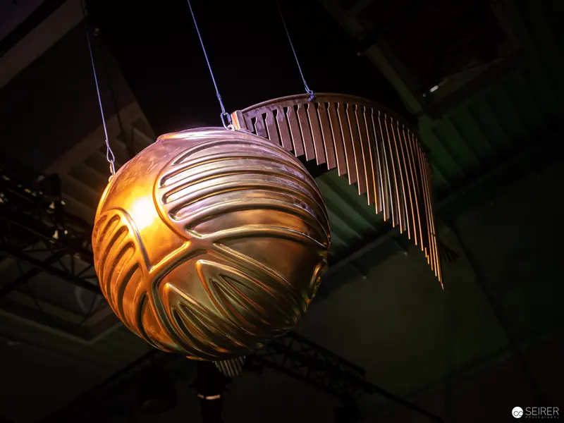 Golden Illuminated Spherical Sculpture with Metallic Wing-like Extensions