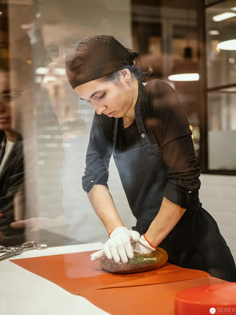 Zuckerlwerkstatt Artisan Crafting Confectionery on Vibrant Orange Surface