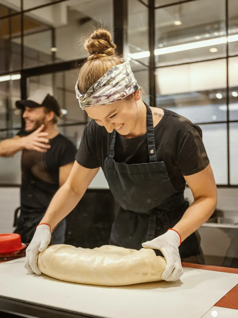 Zuckerlwerkstatt Wien: Baker Preparing Dough with Precision in Commercial Kitchen