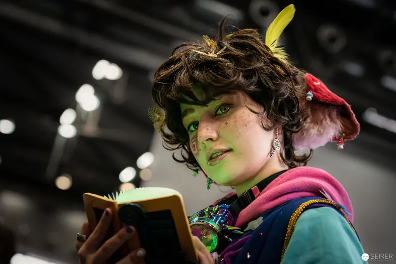 Green-Faced Cosplayer Reading Book at Vienna ComicCon 2023
