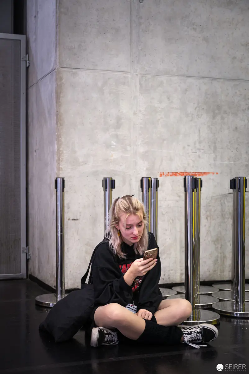 Solitary Moment at Vienna ComicCon: Attendee Engrossed in Mobile Device