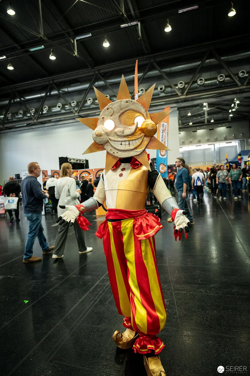 Vibrant Sun Mascot Cosplayer at Vienna ComicCon 2022 Convention Hall